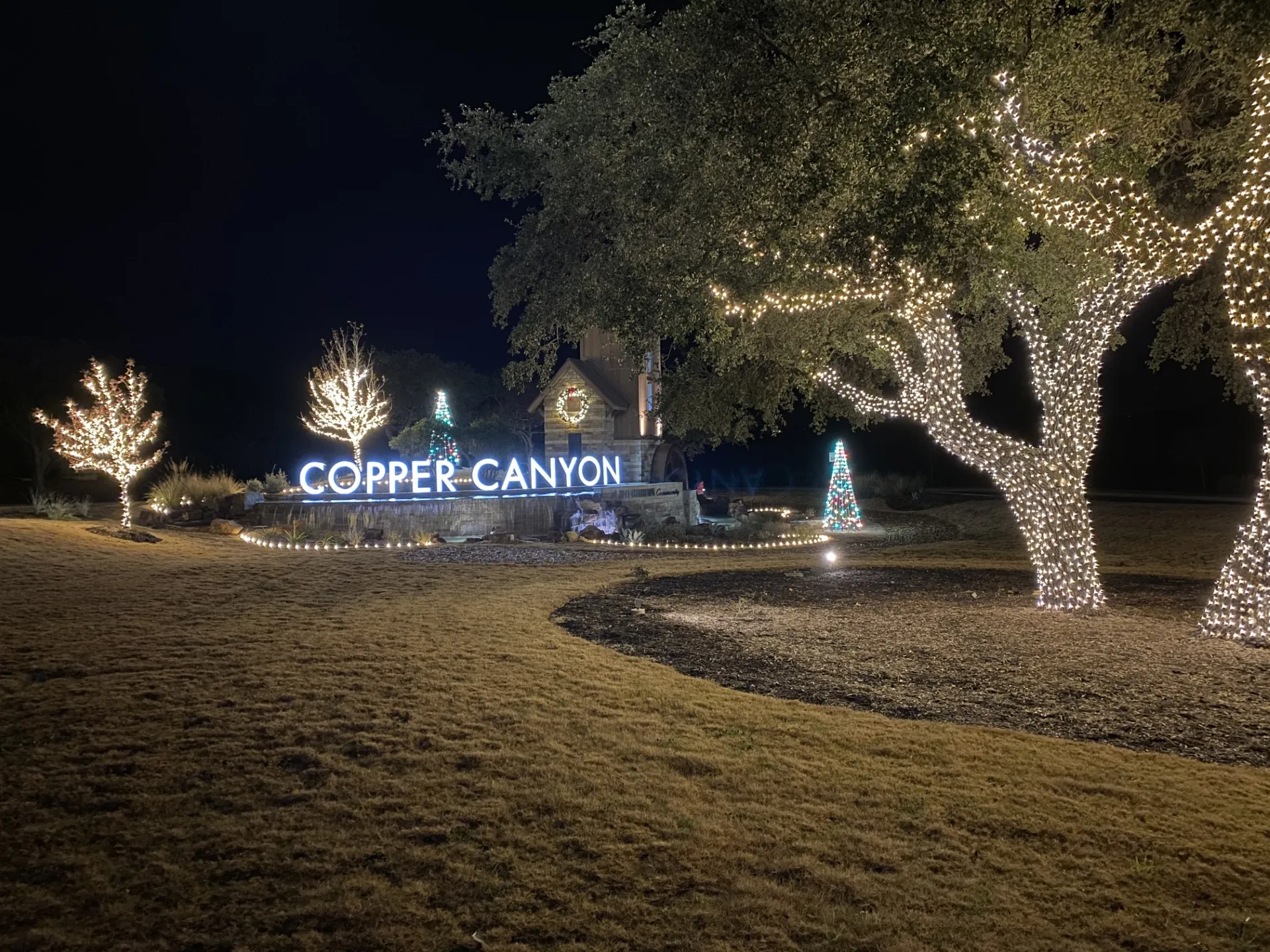 HOA community entrance decorated with holiday lighting